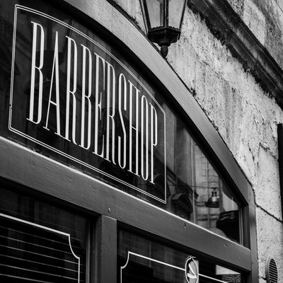 A barbershop&rsquo;s engraved window sign